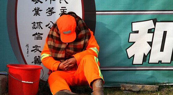 每天必須12小時(shí)在路面值守以時(shí)刻保持路面的清潔，環(huán)衛(wèi)工人只能蜷縮在馬路啃饅頭、打瞌睡